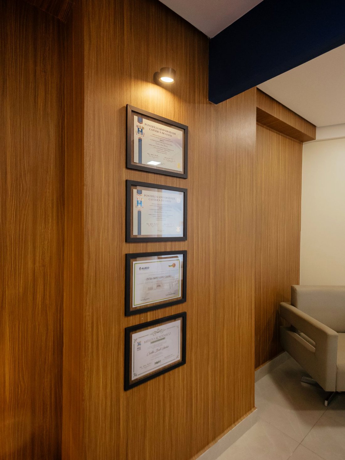 Parede com diplomas e títulos acadêmicos dos sócios da BGL